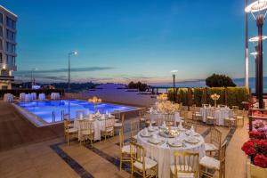 ein Veranstaltungsort für Hochzeiten mit Tischen, Stühlen und einem Pool in der Unterkunft Hampton by Hilton Canakkale Gelibolu in Gelibolu