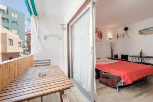 a bedroom with a red bed and a balcony at Estudio El Médano (4) in El Médano