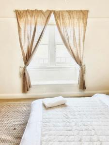 sypialnia z białym łóżkiem i oknem w obiekcie Lurline Lodge w mieście Katoomba