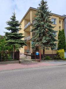 un edificio con dos árboles delante de él en Apartamenty przy Parku, en Łańcut