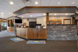 a lobby with a bar with a stone wall at Days Inn & Conference Centre by Wyndham Prince Albert in Prince Albert