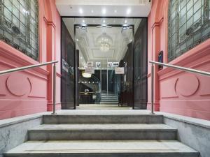 曼徹斯特的住宿－Luxury Stunning 2bedroom city centre，建筑中带粉红色墙壁和楼梯的走廊