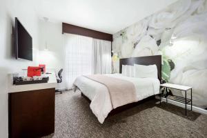 a bedroom with a large bed with a large flower mural at O Hotel by LuxUrban, Trademark Collection by Wyndham in Los Angeles