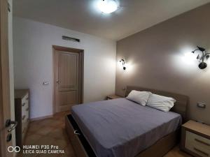 - une chambre avec un lit et deux lumières sur le mur dans l'établissement Le castellane, à Castelsardo