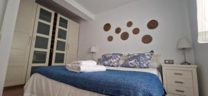 1 dormitorio con 1 cama con manta azul y almohadas en Piso familiar y con encanto, en Sevilla