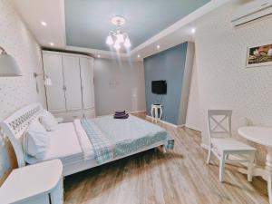 a bedroom with a bed and a table and a chair at Real Home Apartmens - Podil Promenade in Kyiv