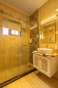 a bathroom with a glass shower and a sink at Shaw Inn by Stay Pattern in Gulmarg