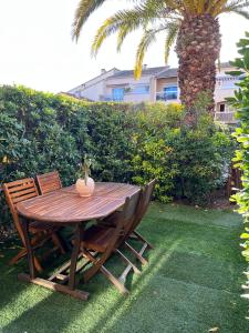 a wooden table and chairs with a vase on it at Les Tropéziennes in Cogolin +7 photos