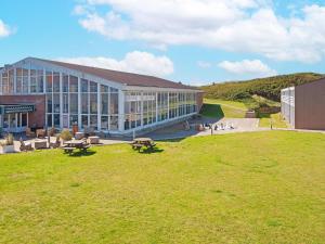 a large building with a grass field in front of it at 8 person holiday home in Ringkøbing-By Traum in Ringkøbing