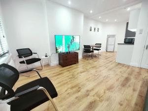 a living room with chairs and a flat screen tv at 3 Bed Flat close to Liverpool st & Brick lane in London