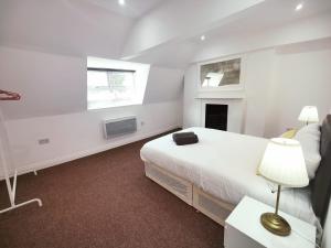 a white bedroom with a bed and a window at 3 Bed Flat close to Liverpool st & Brick lane in London