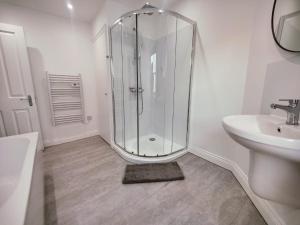 a white bathroom with a shower and a sink at 3 Bed Flat close to Liverpool st & Brick lane in London