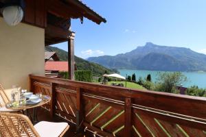 a balcony with a view of a lake and mountains at Naturtalente Berghaus - Moonlakeview s in Innerschwand