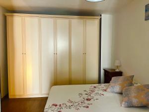 a bedroom with a bed and a large white cabinet at Cattleya in Mola di Bari
