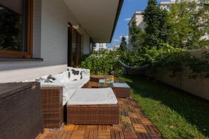 a patio with wicker chairs and a table at Modern Apartment Home Cinema Experience by Renters in Warsaw