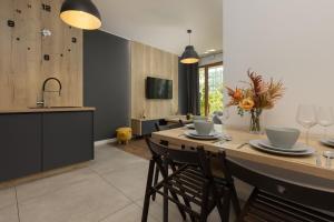 cocina con mesa con sillas y fregadero en Modern Apartment Home Cinema Experience by Renters en Varsovia