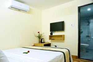 a room with a bed and a tv on the wall at Lisa homestay 2 in Hoi An