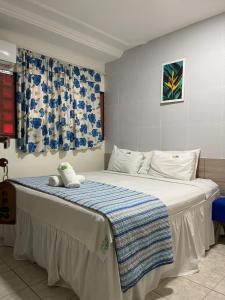 um quarto com uma cama com um cobertor azul e branco em Pousada Cabo Branco em João Pessoa