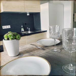 a table with two plates and glasses on it at Schöne Penthousewohnung mit Weitblick in Arnsberg