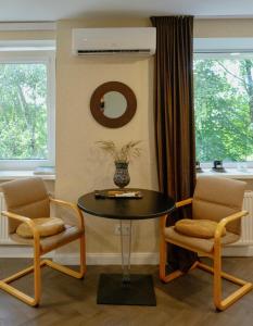 a dining room with a table and two chairs at Petite City Centre Apartment in Šiauliai