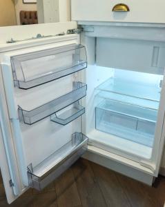an empty refrigerator with its door open at Petite City Centre Apartment in Šiauliai