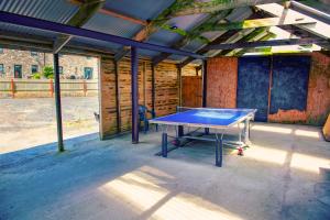 una mesa de ping pong dentro de un edificio en The Gambo Shepherd's Hut, en Kidwelly