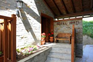 un porche de una casa con un banco y flores en Hotel Rural Irati en Jaurrieta