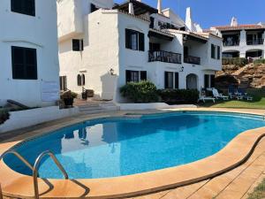 a swimming pool in front of a house at BERGANTIN 109 by SOM Menorca in Fornells