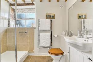 a bathroom with a toilet and a sink and a shower at Horseshoe Cottage Farm with Hot Tub in Leicester