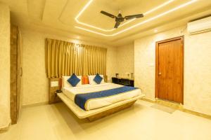 Schlafzimmer mit einem Bett und einem Deckenventilator in der Unterkunft Seasons Suites - Koramangala in Bangalore