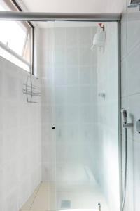 um chuveiro com uma porta de vidro na casa de banho em Quarto de Casal em Apartamento - Belo Horizonte - Buritis em Belo Horizonte