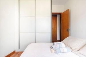 a bedroom with a bed with towels on it at Quarto de Casal em Apartamento - Belo Horizonte - Buritis in Belo Horizonte
