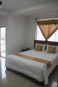 a bedroom with a large bed with a large window at StayHome Away from Home in Cherrapunji