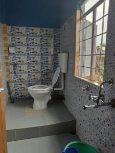 La salle de bains est pourvue de toilettes blanches. dans l'établissement StayHome Away from Home, à Cherrapunji