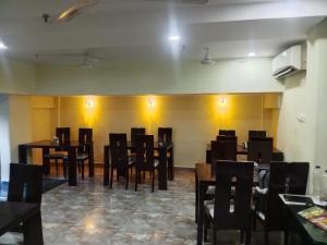 comedor con mesas y sillas de madera en Hotel Holiday Express, en Calcuta