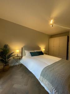 a bedroom with a large white bed and a plant at Tanya's Place-Stylish flat in Marylebone in London