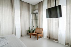 a bedroom with a bed and a chair and curtains at KHouses A2 in Arta