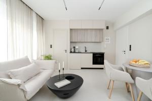 a white living room with a white couch and a table at KHouses A2 in Arta