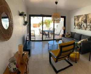 a living room with a couch and a table at One bedroom bungalow Playa Bastian Costa Teguise in Costa Teguise