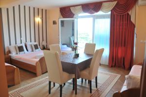 una habitación con mesa y sillas y un dormitorio en Nikić Apartments en Ulcinj
