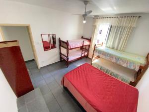 a room with two bunk beds and a window at Pé na Areia Praia da Guilhermina IV in Praia Grande