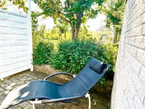 Niebieskie krzesło siedzące obok ściany w obiekcie Cosy apartment with private terrace w mieście Vallensbæk