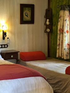 a room with two beds and a table with a lamp at Los Nidos De Santa Maria in Arroyo Frio