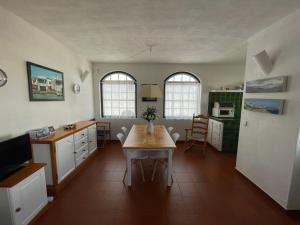 een keuken met een tafel in het midden van een kamer bij SA PUNTA GRAN A2 by SOM Menorca in Fornells