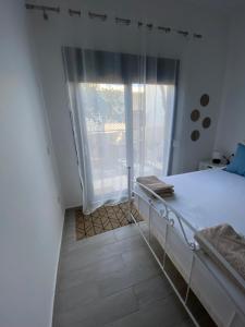 1 dormitorio con cama y ventana grande en Wee Hoose en Skíathos