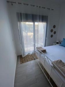 a bedroom with a bed and a large window at Wee Hoose in Skiathos