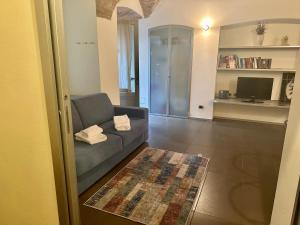 een woonkamer met een bank en een televisie bij FEEL - Luxury Duomo Suite in Bergamo