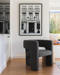 een stoel in een woonkamer met een foto aan de muur bij Luxury 4 Bedroom Beach House with Ocean Views and Smart Technology in Warrnambool