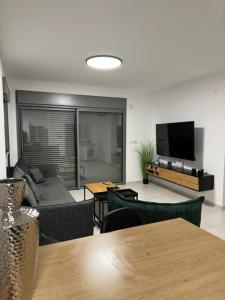 a living room with a couch and a flat screen tv at Elegant 3 bedroom Ocean view Condo in Kiryat Yam in Qiryat Yam