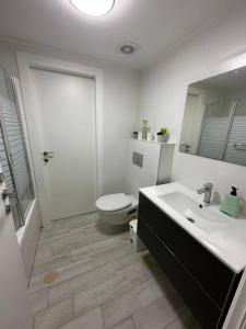 a white bathroom with a toilet and a sink at Elegant 3 bedroom Ocean view Condo in Kiryat Yam in Qiryat Yam
